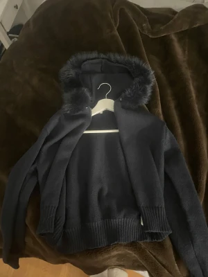 Svart hoodie med fuskpäls från Gina Tricot - ANVÄND 1 GÅNG. Mörkblå hoodie från Gina Tricot i storlek S med mjuk fuskpäls runt huvan. 