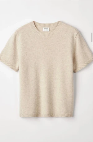 Beige kashmirtröja från Soft Goat - Superskön beige kashmirtröja från Soft Goat med korta ärmar och rund hals. Tröjan har ribbade muddar vid hals, ärmslut och nederkant. Perfekt för dig som gillar stilrena och mjuka plagg med lyxig känsla. Passar till allt och kan användas året om.