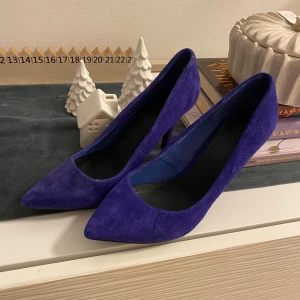 Mocka  pumps - Snygga blå pumps i mjuk mocka med spetsig tå och smal klack. Skorna har en elegant siluett och platt sula framtill. Använda en kväll inomhus 