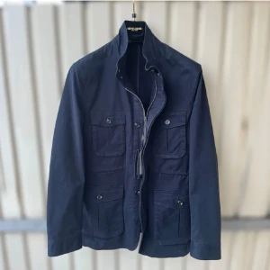 Marinblå FieldJacket från Gutteridge - Snygg marinblå jacka från Gutteridge med fyra stora fickor framtill, dragkedja och knappar. Jackan har hög krage och är tillverkad i bomull. Perfekt för dig som gillar stilren och klassisk look.
