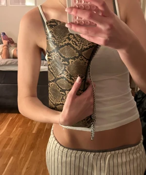 Ormskinns mönster väska  - As snygg Gina väska med silvrigt axelband 