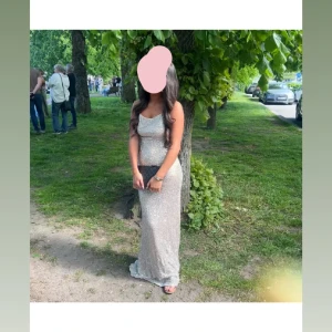 Glittrig långklänning med öppen rygg - Säljer en glittrig guldfärgad långklänning med smala axelband och öppen rygg. Klänningen har en figurnära passform och är perfekt för bal eller fest. Materialet är syntet och den glittriga ytan gör att du verkligen sticker ut.❣️( har en liten sminkfläck på insidan av förra ägare, inget som påverkade mig men går nog bort i en skonsam tvätt!) 