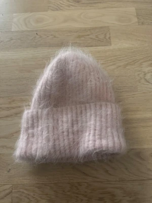 Alvii mössa - Rosa ”fluffig” mössa från Alvii. Den är i nyskick och har aldrig blivit använd utomhus!  79% alpaca, 19% nylon, 2% spandex.