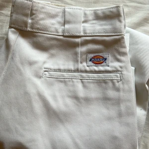 Vita Dickies 874 Original Fit byxor - Säljer ett par klassiska vita Dickies 874 Original Fit byxor. De har raka ben, breda hällor och Dickies-logga ovanför bakfickan. Byxorna är tillverkade i slitstark bomullsblandning och har en clean look som funkar till många stilar.