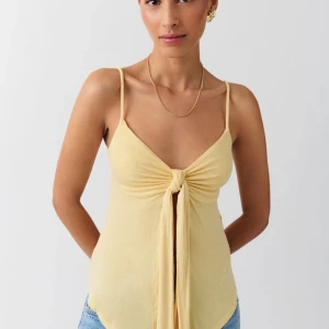 Ljusgul linnetopp med knyt - Supersöt ljusgul linnetopp med smala axelband och snygg knytning framtill. 