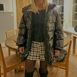 Svart pufferjacka från Zara - Säljer en svart, glansig pufferjacka från Zara med hög krage och dragkedja framtill. Jackan har stora fickor och en oversized passform som ger en cool look. Perfekt för kalla dagar när du vill vara både varm och snygg.