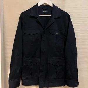 Mörkblå Fieldjacka Riley  - Säljer denna sjukt snygga Fieldjackan från Riley⭐️ Färgen är mörkblå och storleken är M✅ Den har inga defekter och skicket är utomordentligt🙌🤝 Sjukt najs passform och passar perfekt till hösten🍁🙌 Tveka inte på att höra av er dig vid minsta fråga eller fundering😊