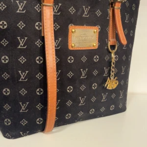 svart axelväska - Svart axelväska med klassiskt monogrammönster och bruna skinnremmar. köpt secondhand! Skriv för fler frågor eller bilder💗 dragkedjan är trasig, men går enkelt att fixa