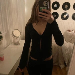 Svart omlottopp med knyt - Svart söt topp, lite nopprig. 