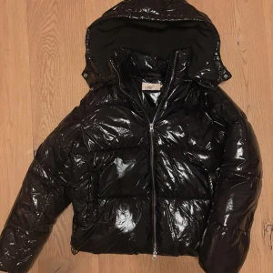 Svart glansig pufferjacka Nelly - Endast använd sparsamt fåtal gånger☺️Säljer pga har andra jackor. Mycket varm. Pris kan diskuteras! Nypris 799 