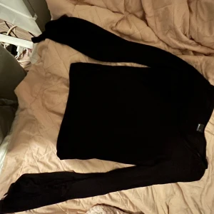 Svart långärmad tröja Gina Tricot - En svart långärmad tröja från Gina Tricot i enkel och stilren design. Tröjan har rund halsringning och är tillverkad i mjukt material som känns skönt mot huden. Perfekt att matcha med jeans eller kjol för en clean look.