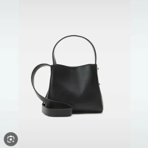 Gina tricot väska  - En knapp har gått bort visar i bild 2, annars i bra skick bandet finns!! Det går fortfarande att använda med bandet 