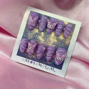 PurpleKuromi(S);Short Almond;Curved - Supergulliga handgjorda press-on naglar i lila med glitter, dekorerade med 3D Kuromi-figurer och 3D swirl-detaljer. Naglarna har en kort mandelform och är perfekta för dig som älskar kawaii och unika naglar. Levereras i storlek S: 15 mm, 11,5 mm, 12 mm, 11 mm, 9 mm .