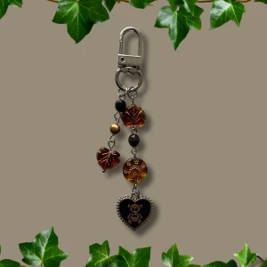 Keychain  - Höstig keychain, habdgjord med tjeckiska glaspärlor, en upcycled sötvattenpärla och en hjärtformad berlock🖤🍁🍄 Går att sätta på väska exempelvis :)