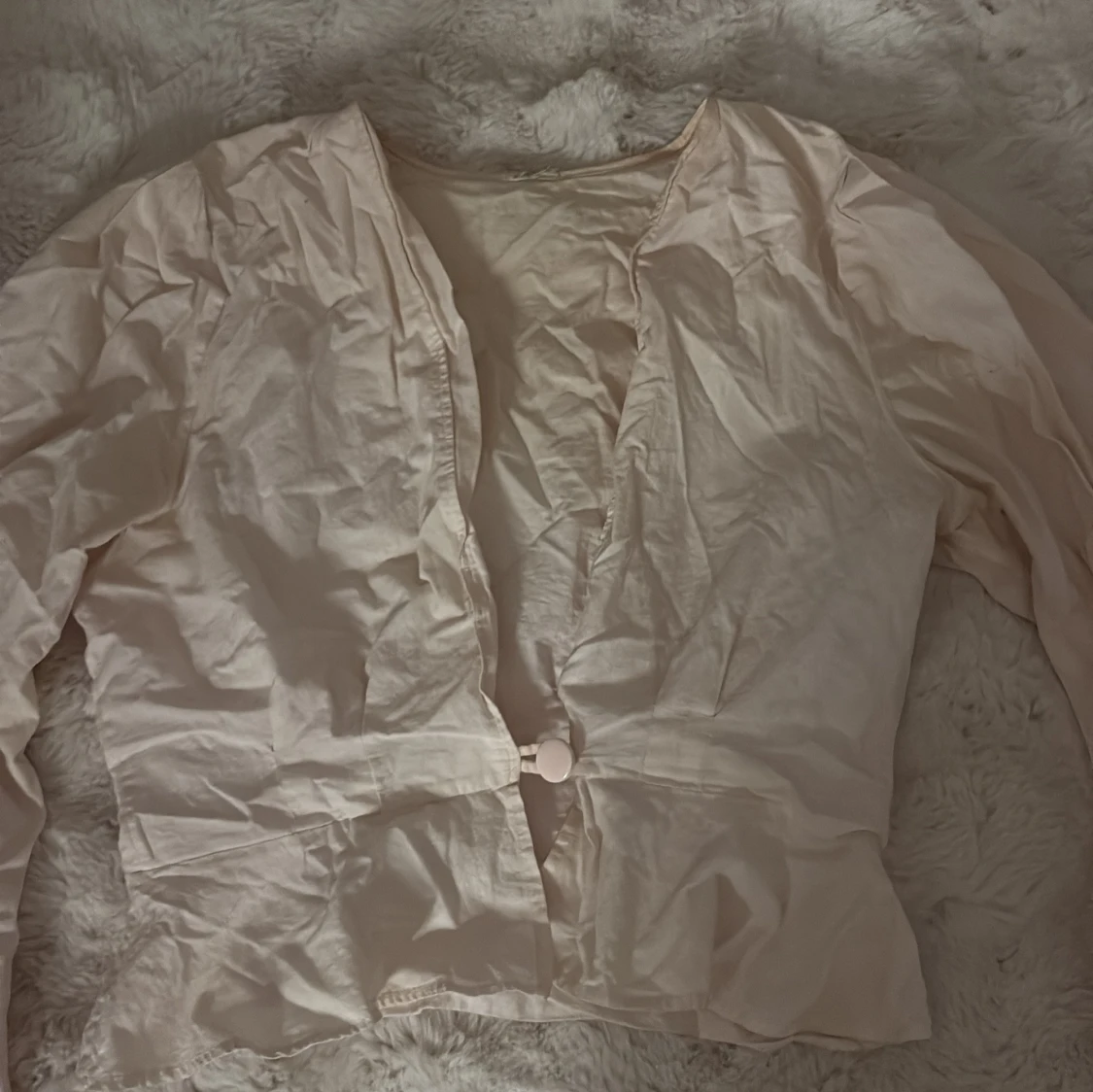 Ljusbeige blus med knappdetalj