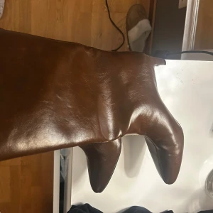 Bruna stövlar med spetsig tå - Säljer ett par snygga bruna stövlar i skinn med spetsig tå och platt sula. Stövlarna har en klassisk, stilren form och är perfekta för alla outfits.  Dom är aldrig använda för köpte fel storlek.