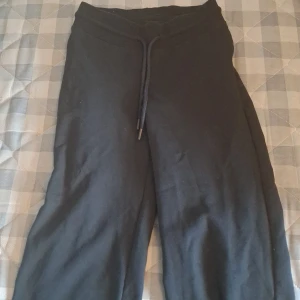 Svarta mysbyxor från 157 XS - Svarta mjukisbyxor från 157 i storlek XS. Byxorna har rak passform, resår i midjan och snörning för extra komfort. Perfekta för chill dagar eller när du vill vara bekväm. Tillverkade i mjukt material som känns skönt mot huden.