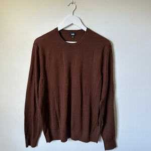 Brun ulltröja från Uniqlo, storlek M - Säljer en stilren brun tröja från Uniqlo i 100% ull. Tröjan har rund halsringning och långa ärmar, perfekt för lager-på-lager under kyliga dagar. Enkel och klassisk design som funkar till det mesta. Passformen är normal och materialet är mjukt och skönt. 3T21
