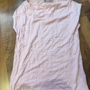 Ljusrosa klänning från 157 - Enkel och stilren ljusrosa klänning från 157. Modellen är ärmlös med rak passform och mjukt bomullsmaterial. Perfekt för varma dagar och enkel att styla med accessoarer. Snygg och basic för en avslappnad look.