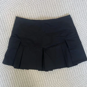 Minikjol - Svart kjol med fickor och dragkedja, knappt använd