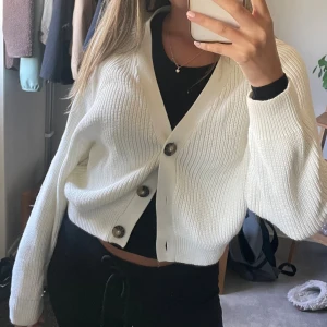 Vit stickad kofta med knappar - Säljer en vit stickad kofta med stora, snygga knappar framtill. 