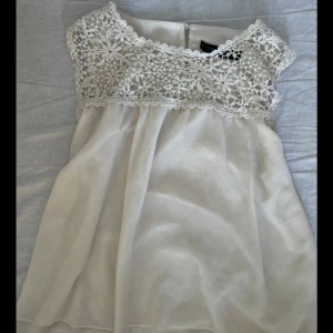 Vit spetstopp från Zanzea - Supersöt vit topp från Zanzea med vackert virkad spets upptill och ärmlös design.