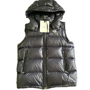 Moncler väst,(äkta) nfc,kvitto - Snygg svart dunväst från Moncler med glansig finish och avtagbar huva. Västen har två dragkedjefickor fram, quiltad design och klassisk Moncler-logga på bröstet. Perfekt för lager-på-lager och streetstyle. Dragkedja framtill för enkel på- och avtagning. Pris går att diskuteras