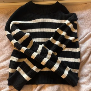 Svartvit randig stickad tröja H&M - Säljer en svart och vit randig stickad tröja från H&M i storlek XS. Tröjan har grov ribbstickning, rund hals och långa ärmar. Perfekt för dig som gillar klassiska mönster och vill ha en mysig, lite loose passform.