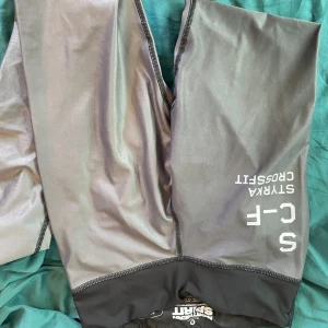 Grå träningsleggings från Northern Spirit - Grå och svarta träningsleggings från Northern Spirit med tryck 'STYRKA CROSSFIT' på benet. Tight passform och stretchigt material som passar perfekt för crossfit eller gym. Snygga kontrastsömmar och bekväm midja.