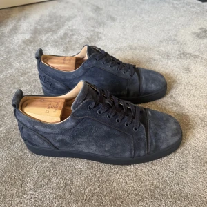 Christian Louboutin - Säljer nu ett par snygga mörkblå sneakers i mocka från Christian Louboutin. Skorna är i fint skick och har inga tecken på användning. Storlek 43 och endast skorna medföljer vid köp. Skorna är 100% autentiska som du kan se på sizestampet (bild 5) och de är köpta av min privata leverantör. Vid ytterligare frågor är det bara att höra av sig. Pris går att diskuteras!😊