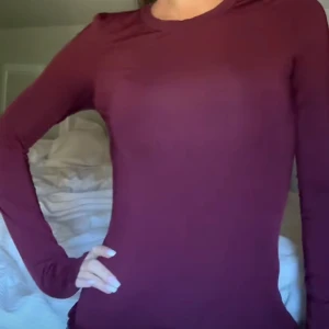 Vinröd långärmad tröja - Säljer en enkel och stilren mörkröd långärmad tröja med rund hals. Tröjan har en tight passform och är perfekt att styla med jeans eller kjol. Superskön och passar till många olika looks.