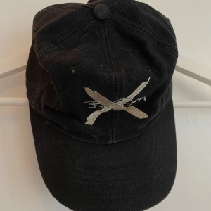 Svart keps BJÖRN BORG  - Svart keps från Björn Borg. Kepsen har böjd skärm och är tillverkad i bomull. Snygg streetstil med slitna detaljer och broderad signatur även baktill.