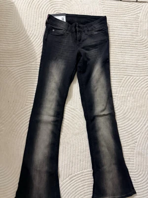 Bootcut jeans från Cheap Monday, svart Helt nyt  - Helt nytt!! Bootcut jeans från Cheap Monday i svart tvätt med snygga slitningar längs benen. Klassisk femficksmodell och normal passform. Materialet är jeans och de har en cool Cheap Monday-logga på bakfickan. Perfekt för dig som gillar en lite retro vibe. Original pris 399kr