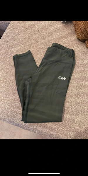 Mörkgröna leggings från ICANIWILL - Snygga mörkgröna leggings från ICANIWILL med vit logga på låret. Stretchigt och mjukt material.