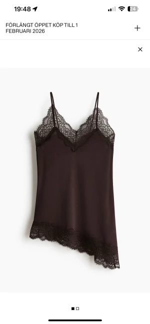 Brunt linnetopp med spetsdetaljer - Helt ny med lapp! Snygg brun linnetopp med tunna axelband och v-ringad hals. Toppen har dekorativa spetsdetaljer längs halsringningen och nederkanten som ger en extra touch. Materialet är mjukt och lätt, perfekt för att skapa en cool och stilren look.