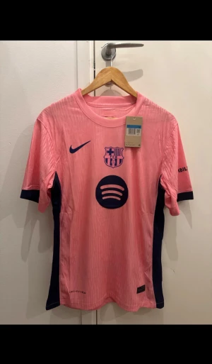 Barça x Nike rosa matchtröja M - Säljer en rosa FC Barcelona matchtröja från Nike i storlek M. Tröjan har mörkblå detaljer, klubbmärke på bröstet och Spotify-logga framtill. Tillverkad i lätt polyester med Dri-FIT-teknik för bästa komfort på planen.