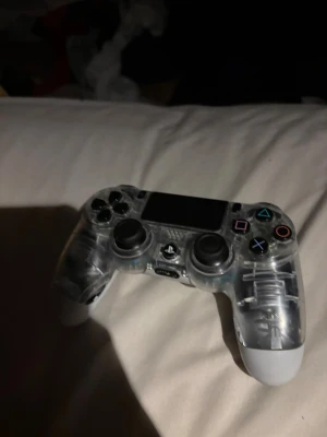 PlayStation 4 DualShock 4 Crystal - Snygg och genomskinlig DualShock 4-kontroll till PlayStation 4. Transparent design som visar insidan. Alla knappar och spakar ser hela ut, inga synliga skador eller större slitage. Perfekt för dig som vill ha en unik PS4-kontroll. Har ett litet hål på sidan men det stör inte när man spelar