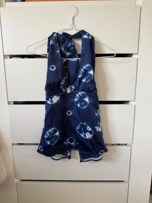 Blå halterneck topp - Säljer denna fina sommartopp från Zara i xs, det är en blå halterneck topp med öppen rygg med knyten i nacken. Toppen är endast använd en gång! 