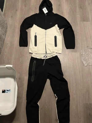  Nike tracksuit, L - Nike tracksuit vit/svart. Aldrig använd. . Perfekt för en chill och sportig look. Storlek L
