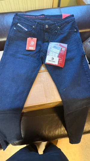 Mörkblå Diesel jeans tapered fit - W-31 L-31 har alla storlekar !  Snygga mörkblå jeans från Diesel med klassisk femficksdesign och diskreta detaljer. Modellen har en tapered passform som sitter skönt och ger en modern siluett. Jeansen är tillverkade i mjukt denimtyg med stretch för extra komfort. Perfekt för dig som gillar stilrena och coola jeans.