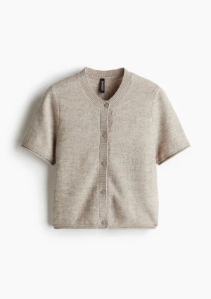 Beige stickad kortärmad kofta - Säljer denna slutsålda stickade koftan från H&M. Använd fåtal gånger och i nyskick. 