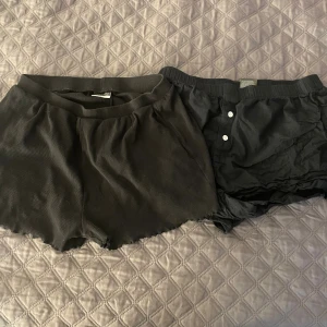 Svarta shorts från H&M och ribbade shorts - Två par svarta shorts i storlek M och L☀️🌞🌻Ena paret är från H&M, har knappar framtill och är gjorda i mjuk bomull med elastisk midja❄️Det andra paret är från beloved och har ribbade, har vågig kant nedtill och bred resår i midjan. Perfekta för chill eller häng hemma🍂🍁