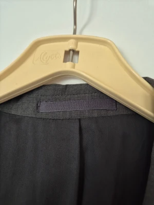 Kavaj - Snygg grå kavaj från Uptown Classic i klassisk modell med tre knappar framtill och två fickor med lock. Kavajen har en rak passform och är tillverkad i ett lätt, vävt material som ger en stilren look. Perfekt för dig som gillar enkel och tidlös stil.