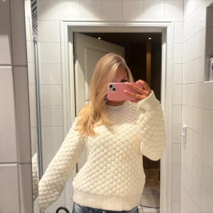 Vit stickad tröja med rutmönster - Säljer en supermysig vit stickad tröja med rutmönster. Tröjan har rund hals, långa ärmar och breda ribbade muddar vid ärmslut och nederkant. Perfekt nu till vintern! Varm och fluffig 🩷🩷Aldrig använd!!