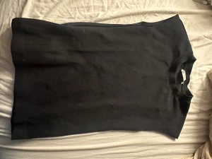 Svart ärmlös tröja från Zara - Svart, stilren tröja från Zara i storlek S. Modellen är ärmlös med rund halsringning och har en enkel, clean look som funkar till många olika stilar. Materialet känns mjukt och bekvämt, perfekt för dig som gillar minimalistiska plagg.
