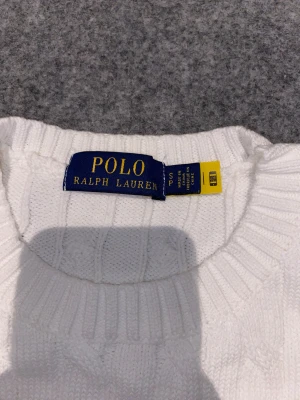 Vit kabelstickad tröja från Polo Ralph Lauren - Säljer nu min vita stickade tröja från Ralph Lauren. Den är väldigt skön och bekväm. Kvaliteten och skicken är väldigt bra!         Han på bilden är 172-174 cm.