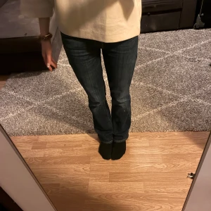 Levi's mörkblå bootcut jeans - Snygga mörkblå jeans från Levi's med klassisk bootcut passform. Jeansen har fem fickor, tydliga sömmar och en stilren look som funkar till många olika stilar. Materialet är slitstarkt jeans och midjan är normal. Perfekta för dig som gillar tidlös denim.