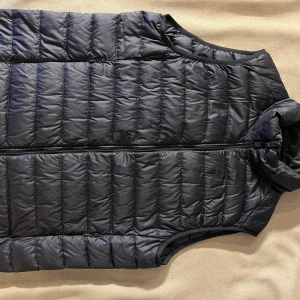 Uniqlo marinblå dunväst  - Uniclo marinblå dunväst. Storlek xs passar s också. 