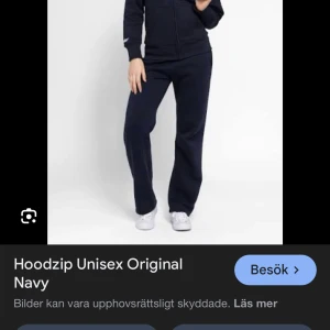 Marinblå hoodie med dragkedja, M - Snygg marinblå hoodie från Original i storlek M. Tröjan har vit snörning i huvan, praktisk dragkedja framtill och två fickor. Mjuk och skön bomullsmix, perfekt för chill eller träning. Klassisk passform med långa ärmar och huva.