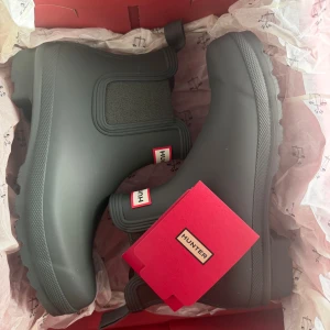 Svarta Hunter chelsea boots - Snygga Hunter stövlar i färgen Dark Olive. Perfekt för regniga dagar. I storlek 39. Säljs pga att jag inte hann lämna tillbaka de till butiken. Nypris 1400